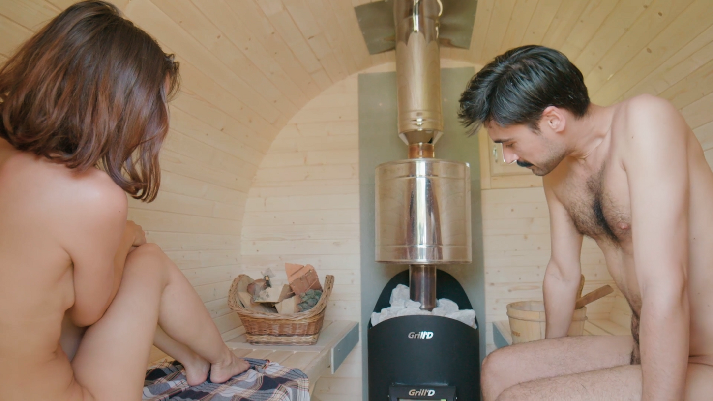 On the Mobile Sauna Berlin episode of Sauna Channel, A man and woman sit down and share a barrel sauna together.