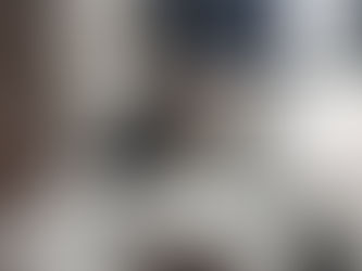 A grey rat peeking out from behind a blanket