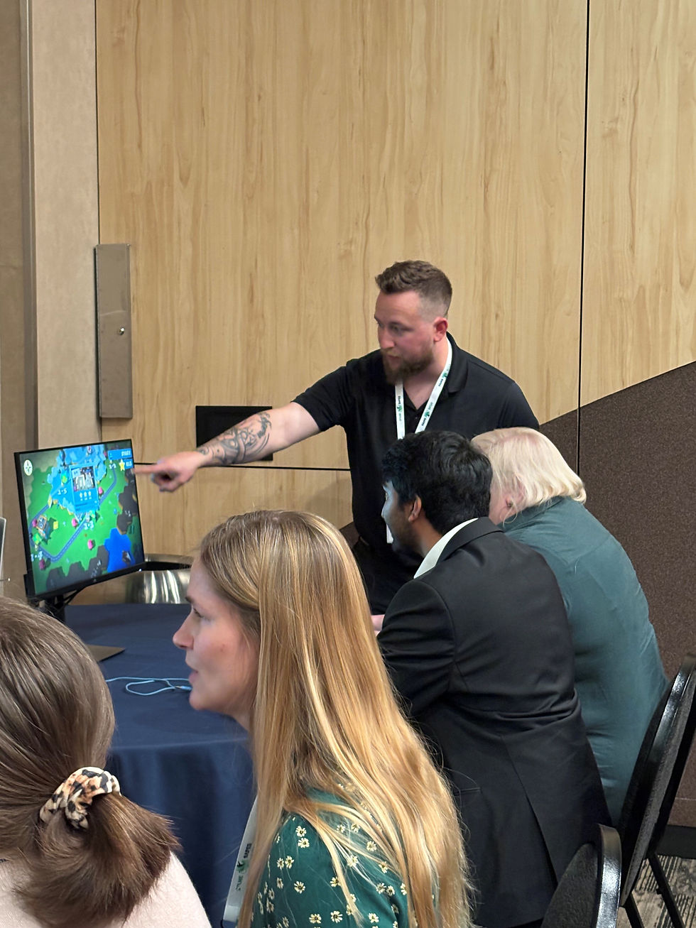 Man helping participants play OverCooked 2 game on monitor