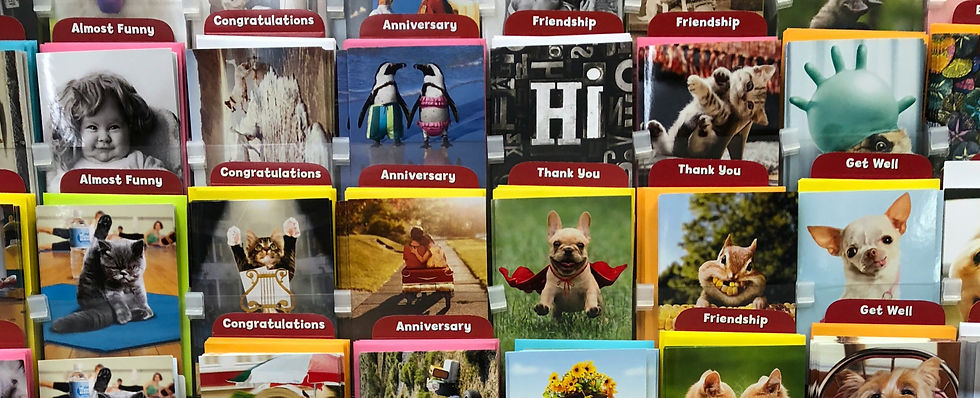 Greeting cards on display feature animals, kids, and humorous themes. Categories include "Almost Funny," "Get Well," and "Thank You."