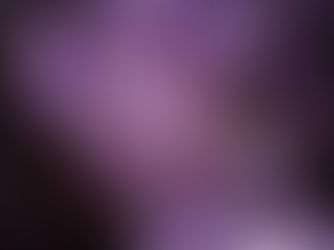 Close-up of purple amethyst crystals with sharp edges, sparkling in light. The background is dark, enhancing the vivid purple hue.