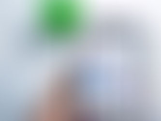 Hand holding a phone showing Instagram profile with Follow and Message buttons; blurred green plant in the background.