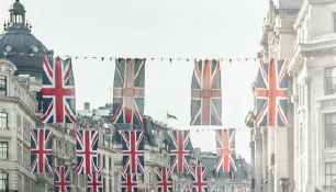 British flags hang across a classic street with ornate buildings. Text reads "High Street Heroes" beside a Union Jack graphic.