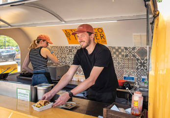 Man serving food at Taco Trailer food truck