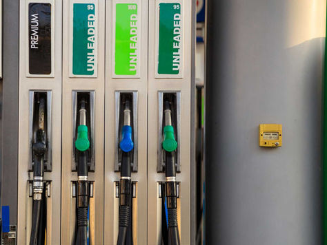 Fuel pump with labels: Premium and Unleaded 95, 100. Green and blue nozzles below. Yellow emergency button on the right.