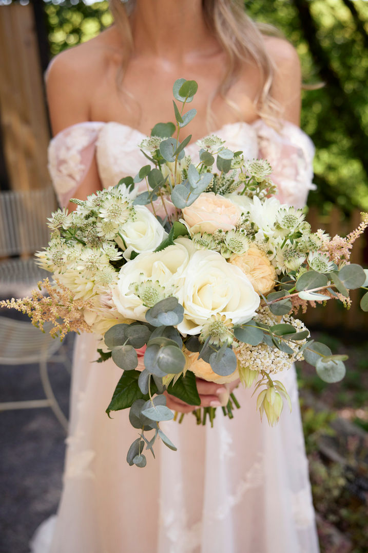 Bride holding lush white and green wedding bouquet