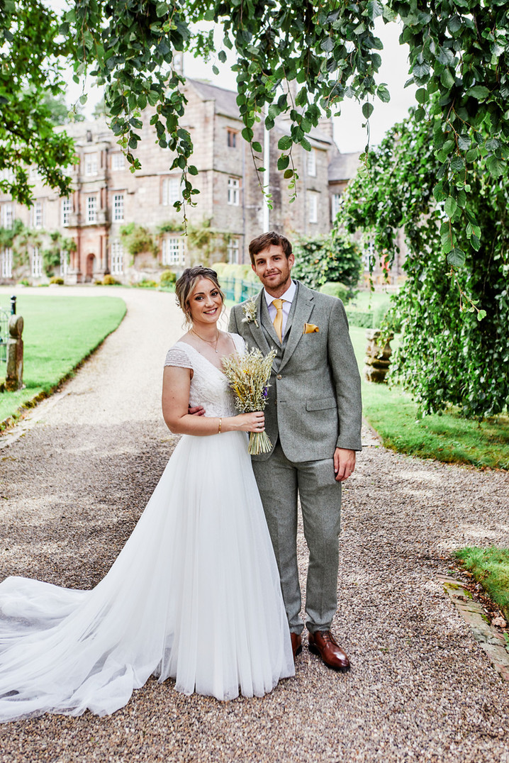 Wedding couple on path outside stone building