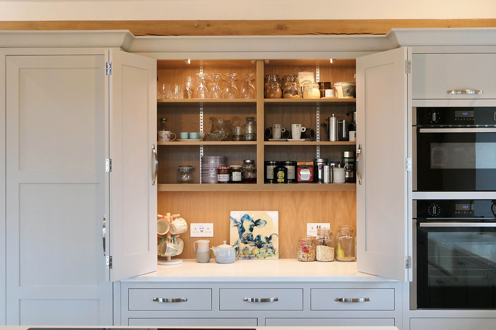 this handcrafted countertop cupboard features oak shelving, practical bi-folding doors, integrated LED lighting and soft grey kitchen cabinetry