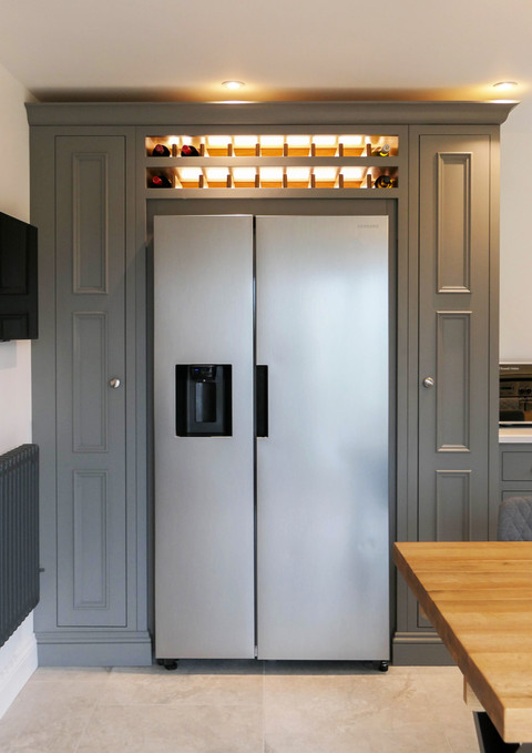a handcrafted shaker kitchen painted in a dark grey colour and paired with satin nickel handles and oak accessories.