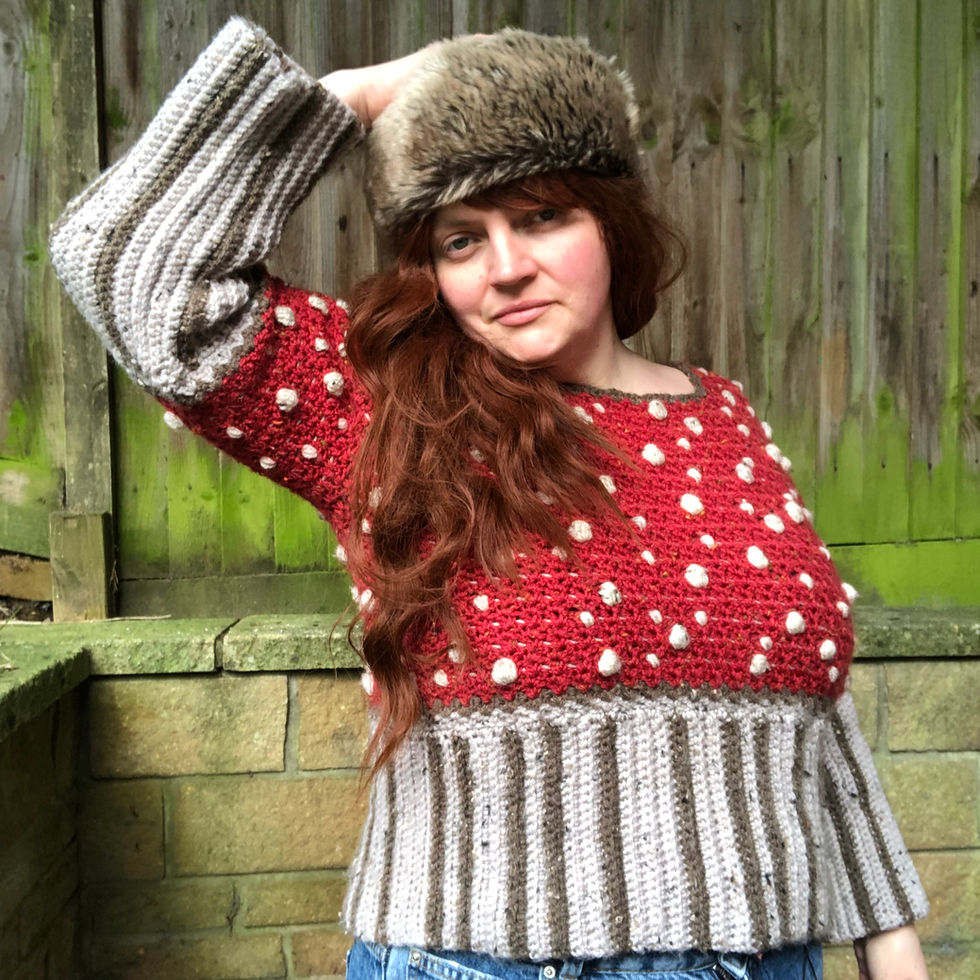 Woman wearing a mushroom sweater and fur hat posing outdoors on a sunny day.