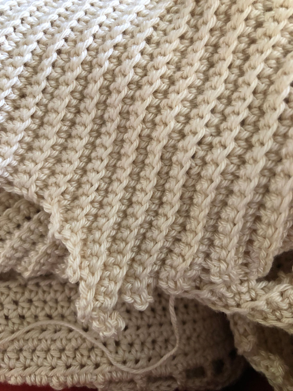 Close-up of a crocheted top in cream colour, with textured pattern
