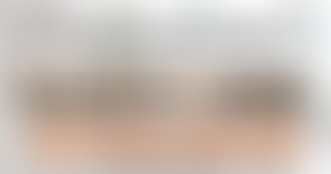 A relaxed female CEO sitting with her feet up on an executive desk in a modern office decorated for the holidays. She is smiling and holding a mug, while her laptop screen displays a large green security shield icon, indicating her IT systems are secured by EASICOMM. City skyline visible through large windows in the background.