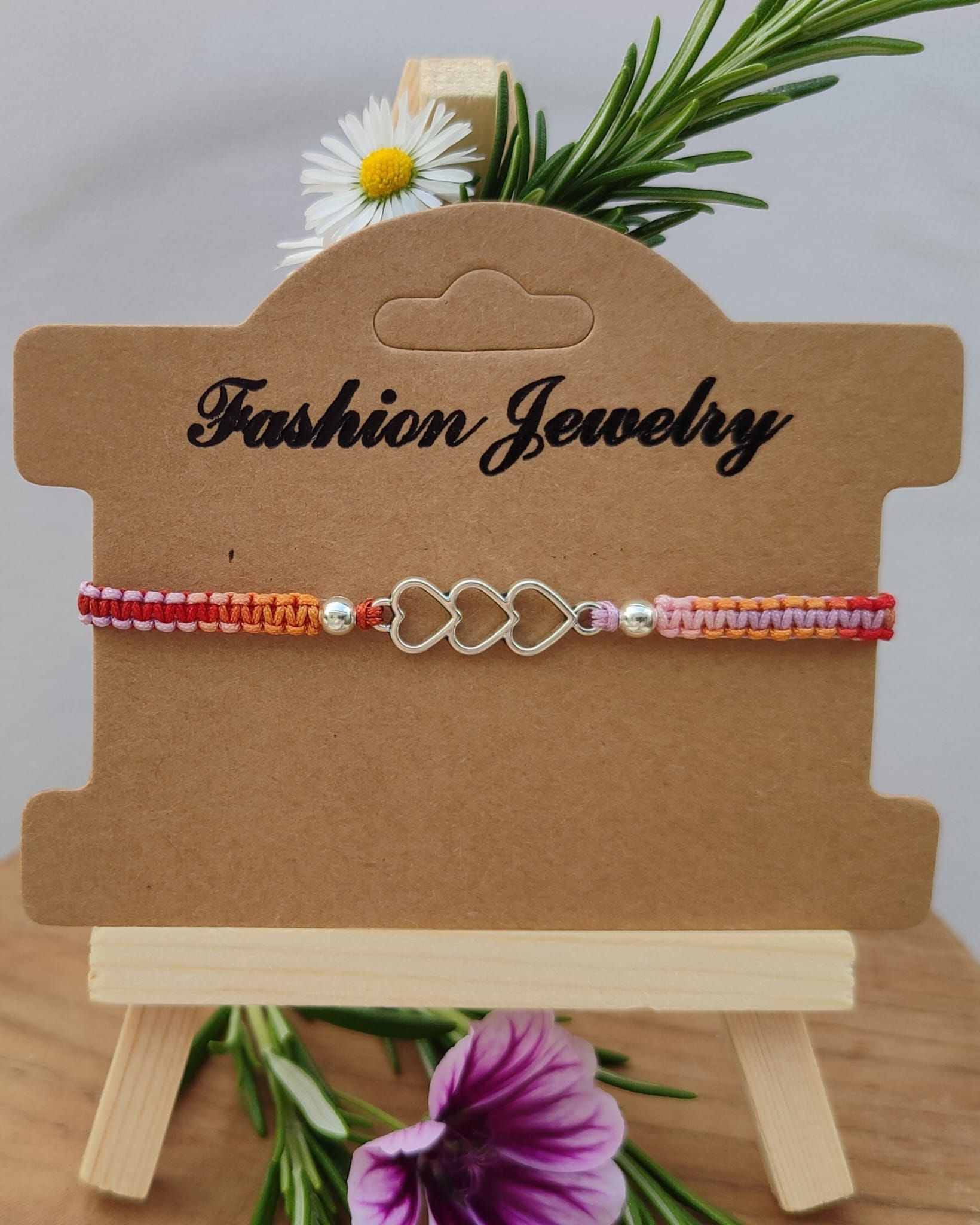 Bracelet macramé multicolore avec un connecteur trois cœurs.