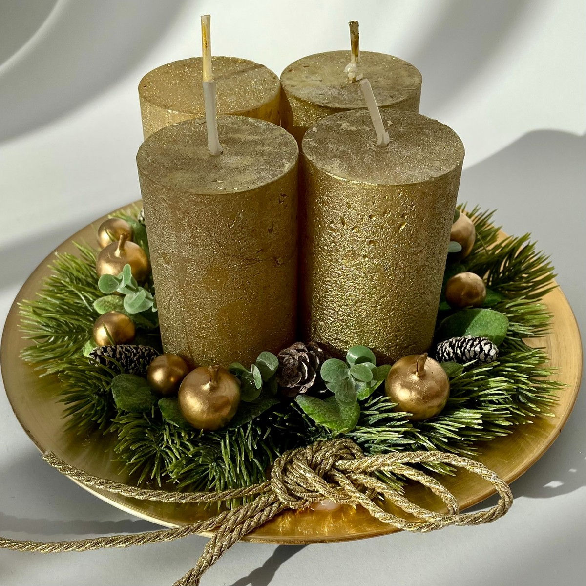 Aranyszínű asztalidísz gyertyákkal