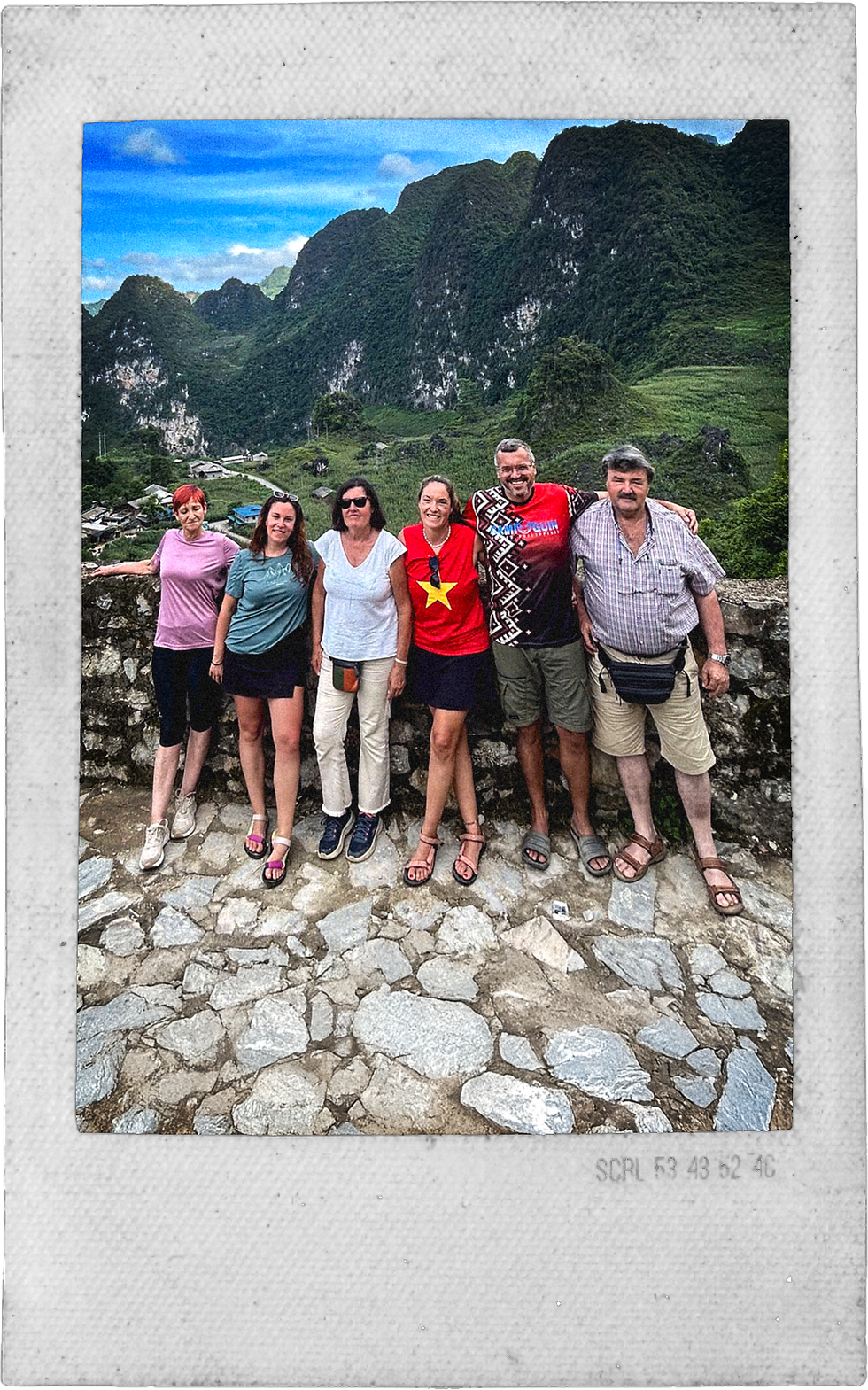 Familia disfrutando de un tour privado con Borderlands en Ha Giang, con montañas escénicas al fondo