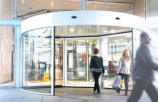 Entrada de edifício com porta giratória automática instalada pela Supervision.
