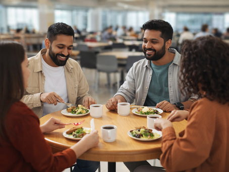 group of four happy employees enjoying a meal at their corporate cafeteria
