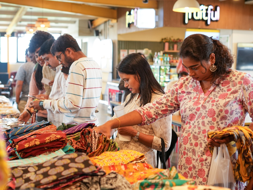Employees looking at items at a SmartQ flea market in a managed cafeteria