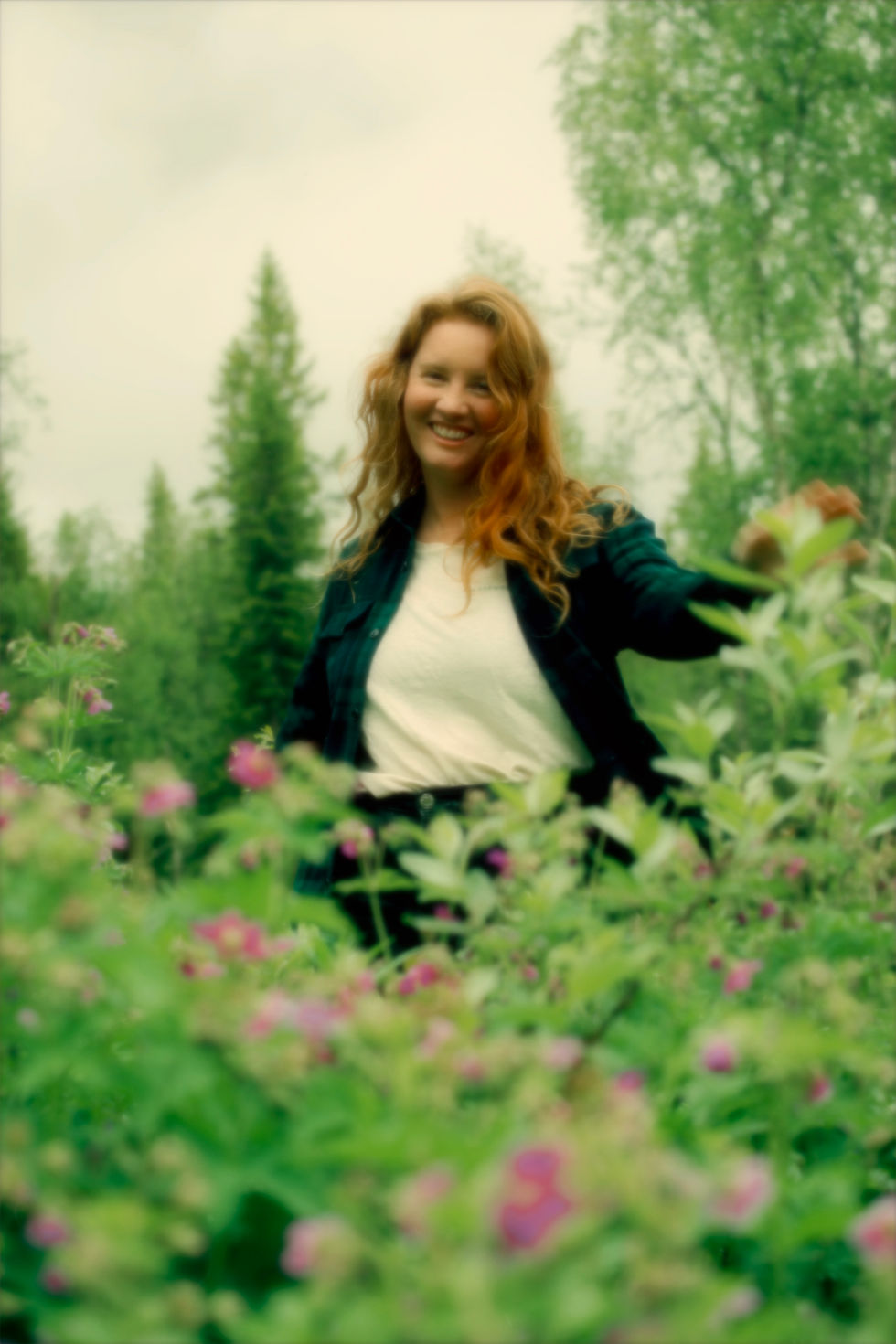 Fotograf Louise F Garbergs lär dig fota manuellt. Rödhårig kvinna dansar bland rosa blommor.