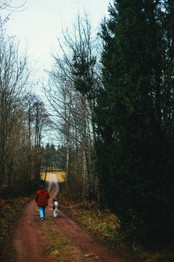 Kvinna i röd jacka på promenad med alaskan malamute