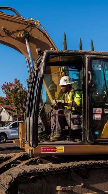 Operator in an excavator on a sunny job site