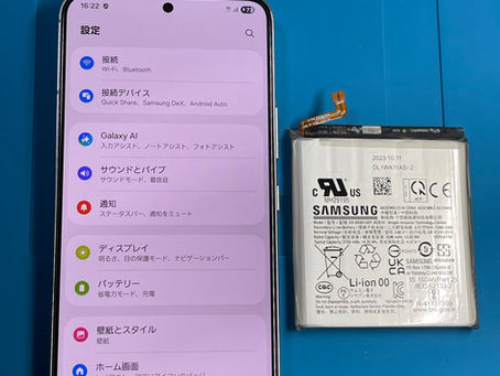 Galaxy S22のバッテリー交換後、起動と動作確認を行っている画面と取り外したバッテリー