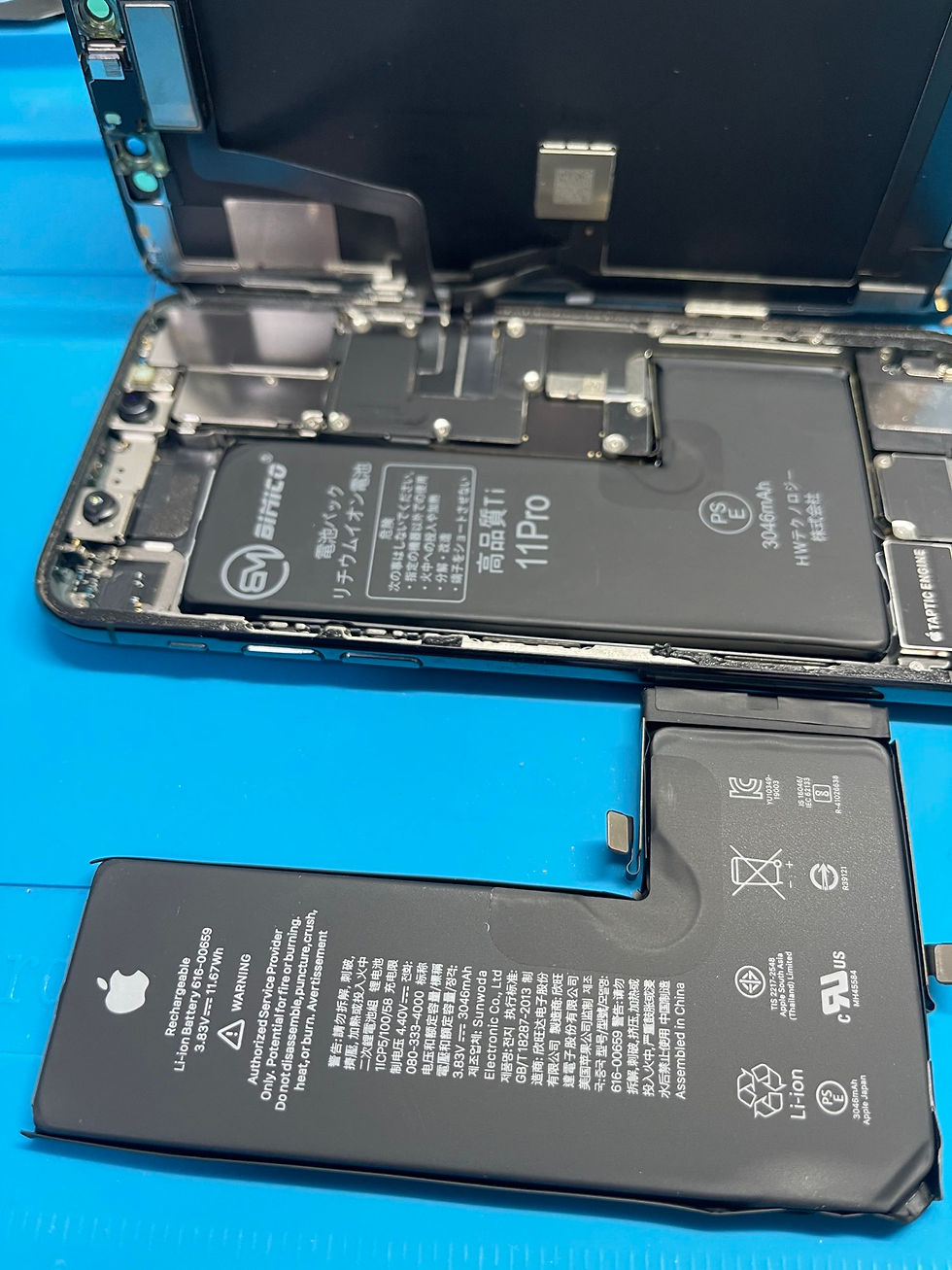 iPhone 11 Proの劣化したバッテリーを取り外し新しいバッテリーと比較している写真