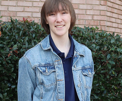 Media Coordinator Eliza Boyd. A young woman with short brown hair smiles at the camera