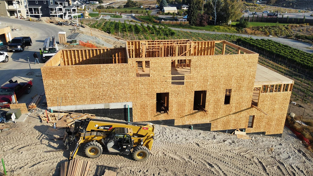 New house framing under construction, skid-steer loader