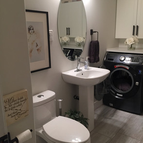 We gutted the entire room, and chose to create a laundry room with a 2-piece bathroom as there was an existing suite in the basement with shared laundry.
We wanted our own laundry room so started by removing and boarding up the window, installed new vinyl flooring, a pedestal sink, a low flush toilet, new cabinetry for storage and we also installed a new linen closet behind the bathroom door.
For resale purposes we boarded the entire bathroom with green board for a future shower.
This way there were choices to either have a shower with a stacking washer/dryer or to simply remove the washer/dryer completely and install a 4-piece bath once again.