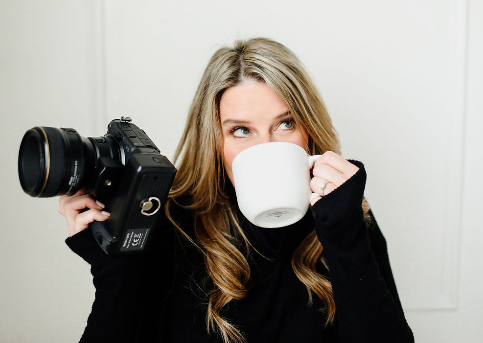 Lacy Wallin Photographer Owner of East Oaks Photography and 8th Street Studio drinking coffee holding camera 