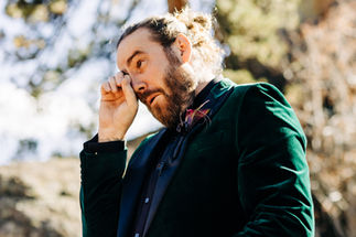 groom in green velvet suite crying during first look