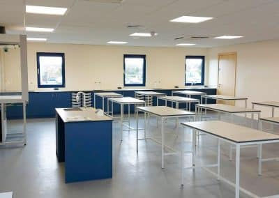 Bright educational laboratory with stainless steel lab bench surfaces and spacious science workstations