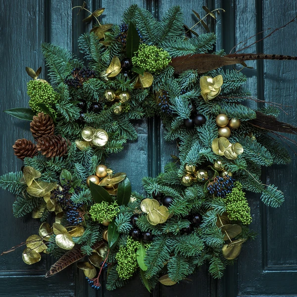 a christmas wreath is hanging on a blue door