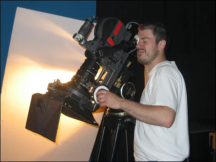Director Pascal Adant operating a Super 16 Arriflex SR-3 motion picture camera on a film set.