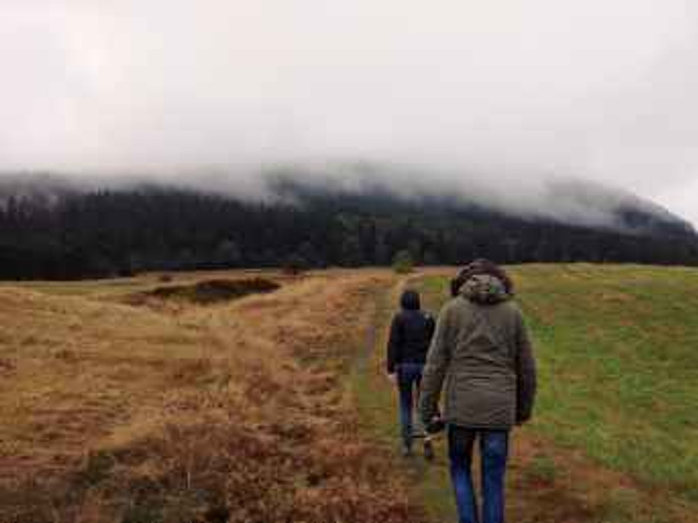 two people walking on field