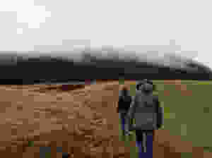 two people walking on field
