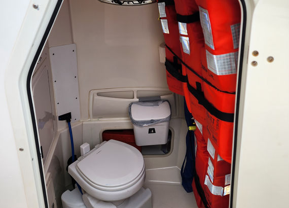 A photo showing the entry door down into the head on the Bonnie Lee, located below the console.