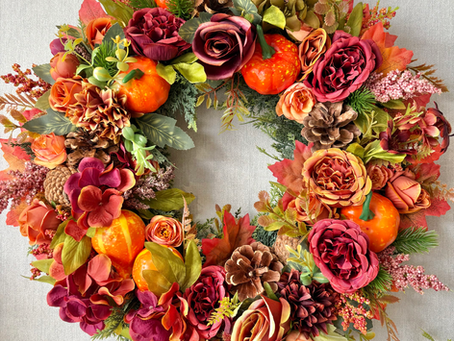 Handmade autumn wreath with orange and burgundy faux flowers