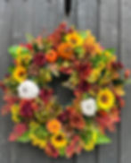 Autumnal half wreath with sunflowers, pumpkins, and roses
