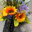 Thumbnail: Sunflowers and purple flowers in a black vase