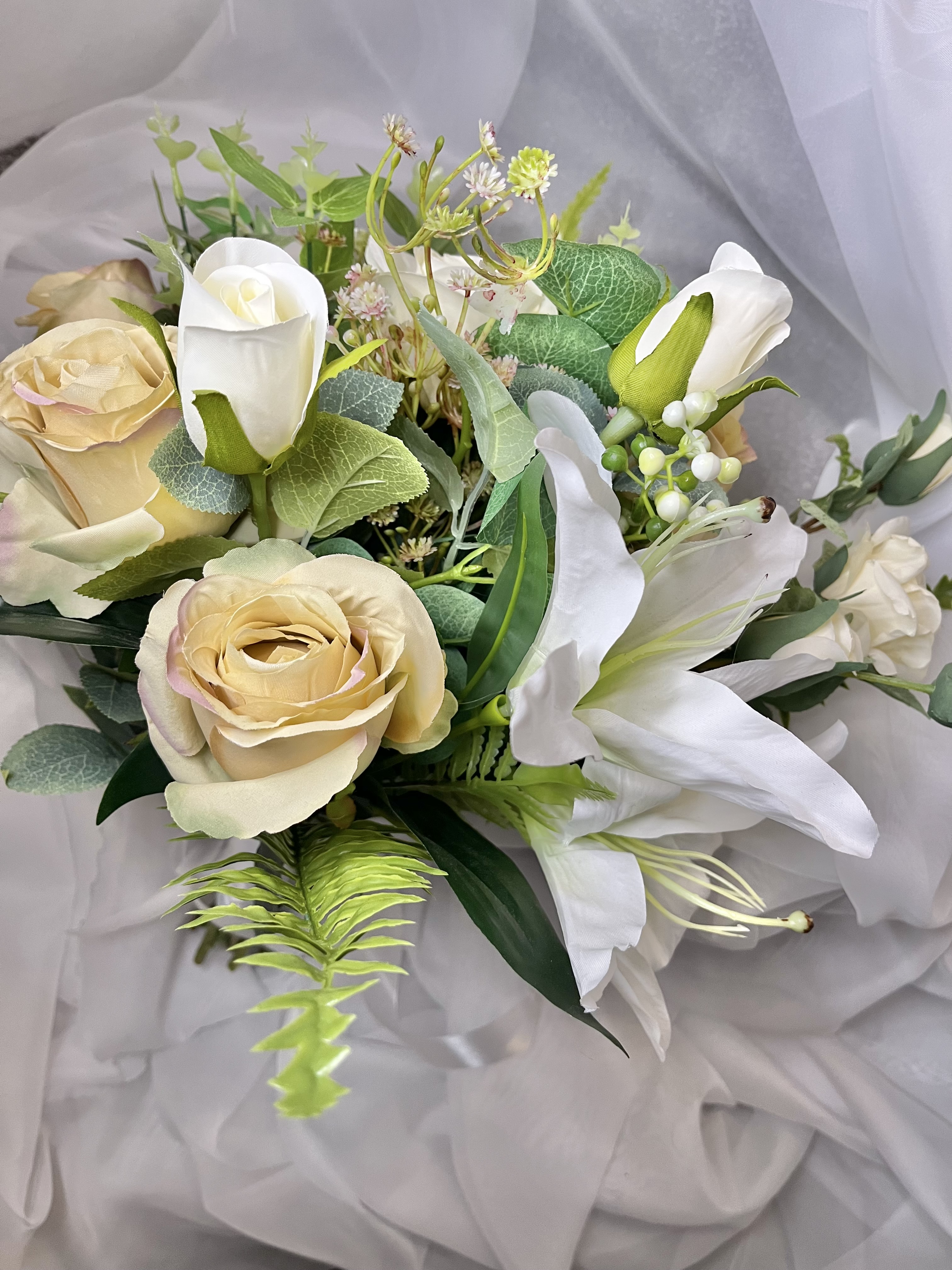 Detailed close-up of intricate artificial wedding flowers in soft pastel tones.