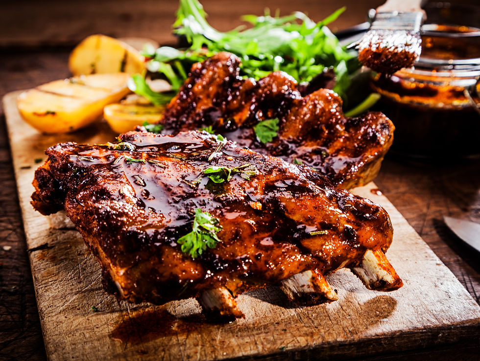 Glasierte und karamellisierte Argentinische Costillas auf Holzbrett.