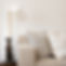 White themed sofa set with floor lamp beside it.
