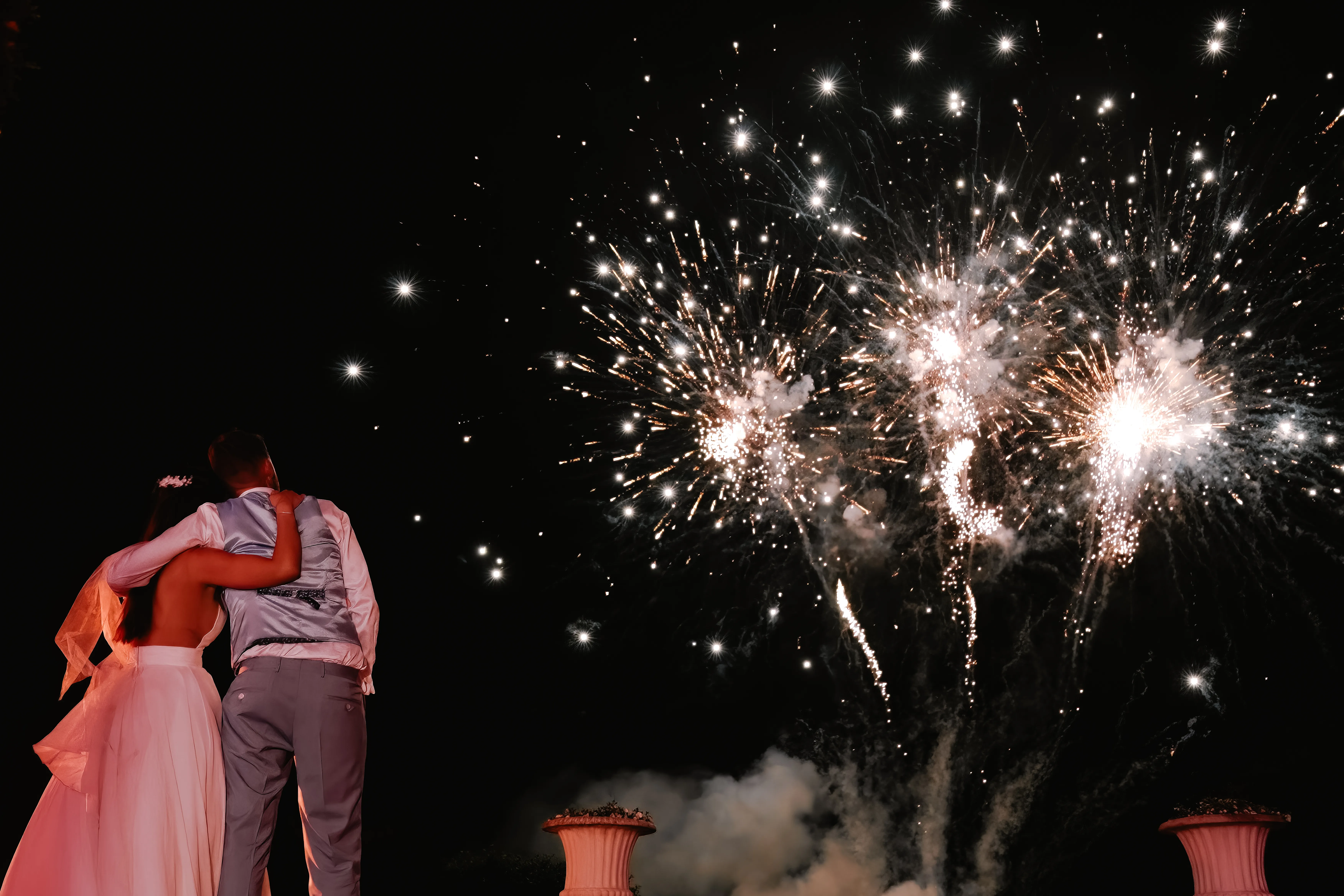 Les mariés de dos regardent le feu d'artifice, moment magique capturé par HDAS Records, photographe à Bordeaux