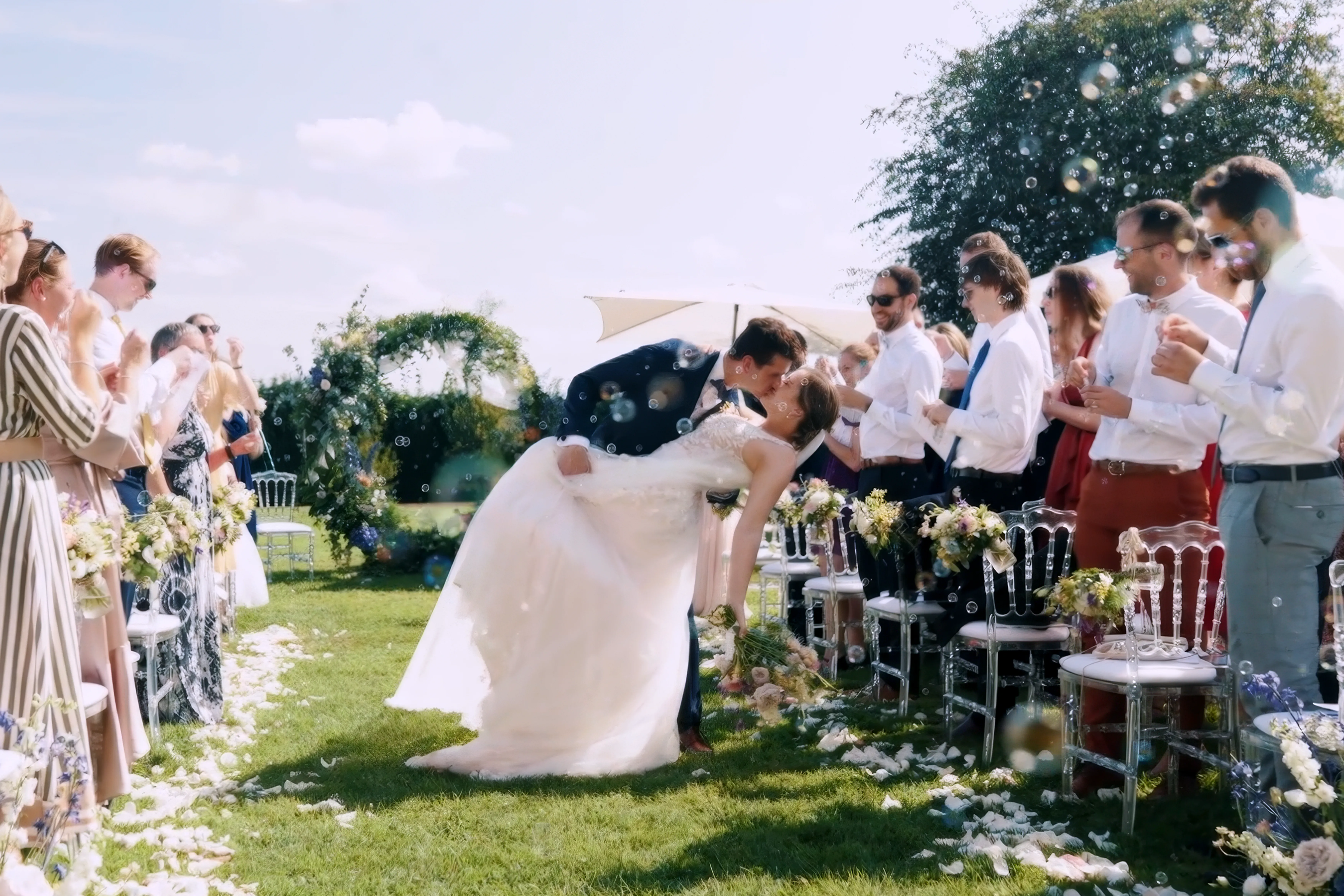 Le marié embrasse la mariée à la sortie de la cérémonie laïque, moment capturé par HDAS Records, photographe à Bordeaux