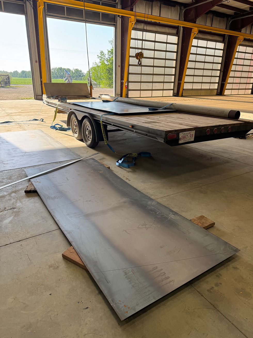 Steel plate material prepared for custom fertilizer hopper fabrication prior to cutting, layout, and assembly at CAKI Fabrication.