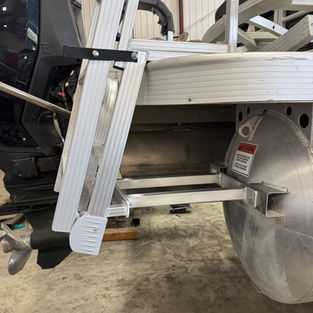 Close-up of two aluminium braces welded to mounting plates on the side of a pontoon boat.