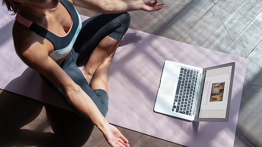 student following a yoga gently pre recorded class via laptop computer