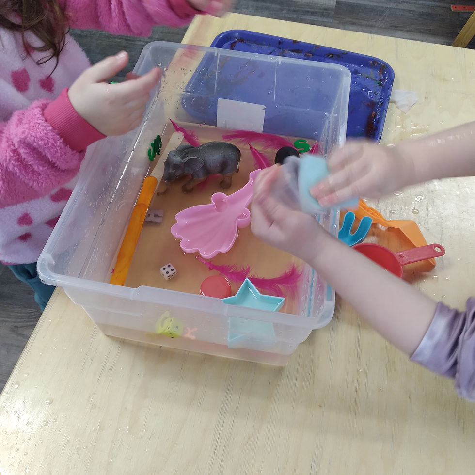 preschoolers exploring variety of objects in clear bin of water for safari sink or float activity